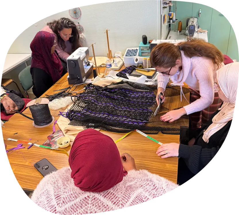 Participants réunis autour d’une création textile lors d’un atelier couture Passerelle
